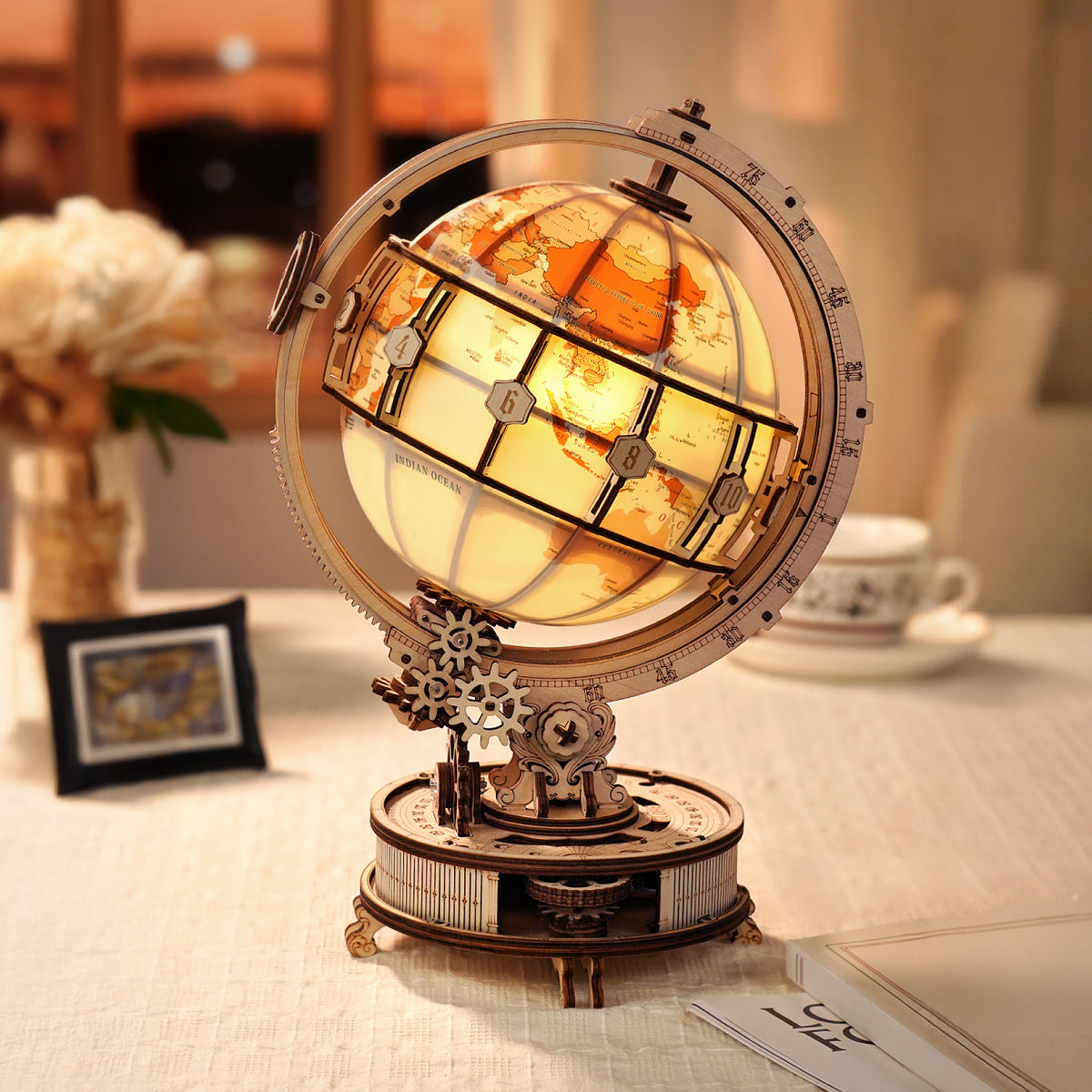 Le globe lumineux, dans sa version avec moteur, s'illumine sur une table, avec un socle plus haut