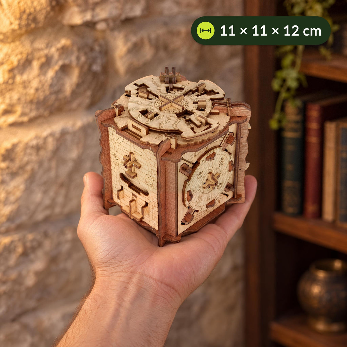 Cluebox The Trial of Camelot op je handpalm, zo’n 11 cm breed en 12 cm hoog, voor een stenen muur