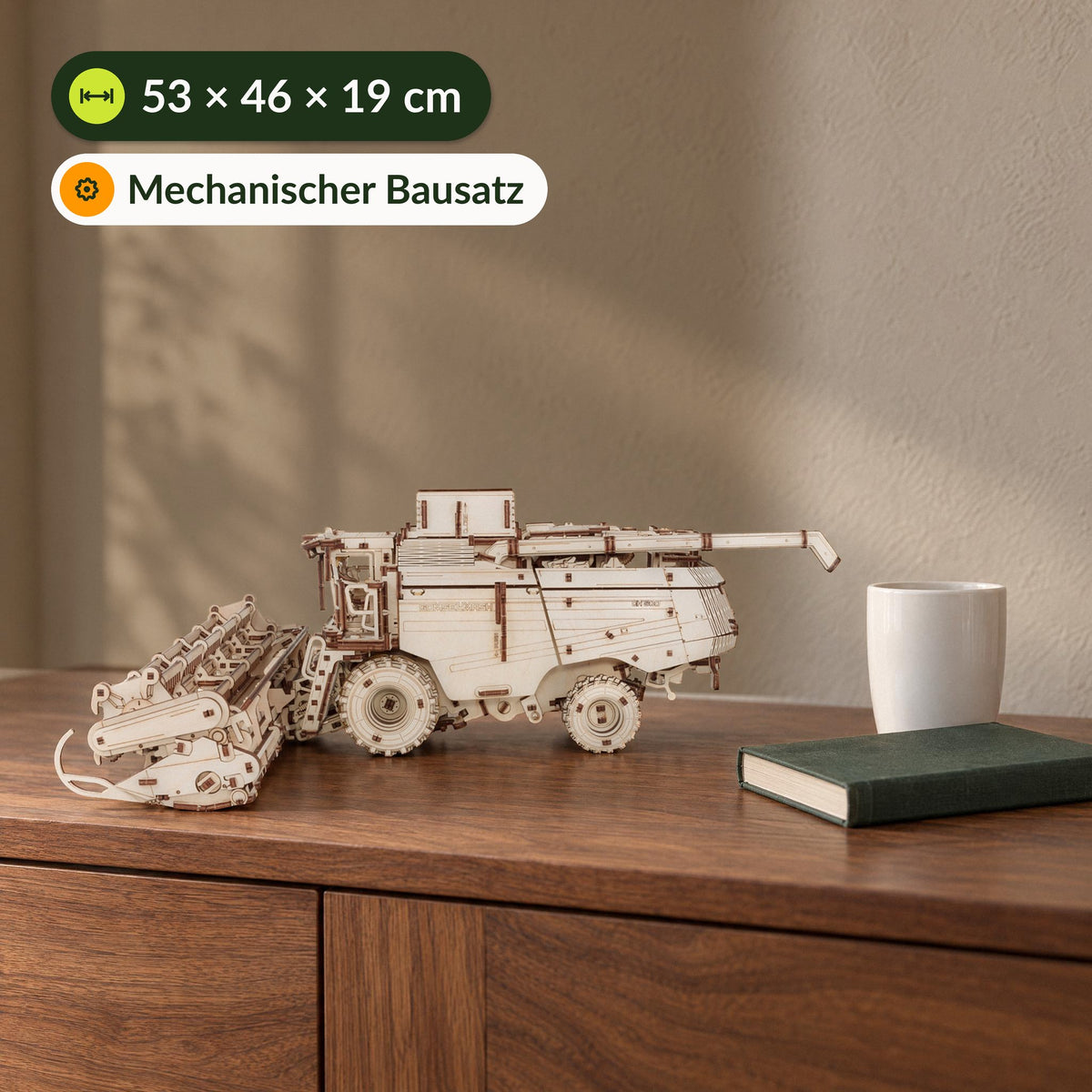 Mähdrescher mit Schneidbalken, 53 x 46 x 19 cm großes Holzmodell auf einem Sideboard neben Tasse und Buch