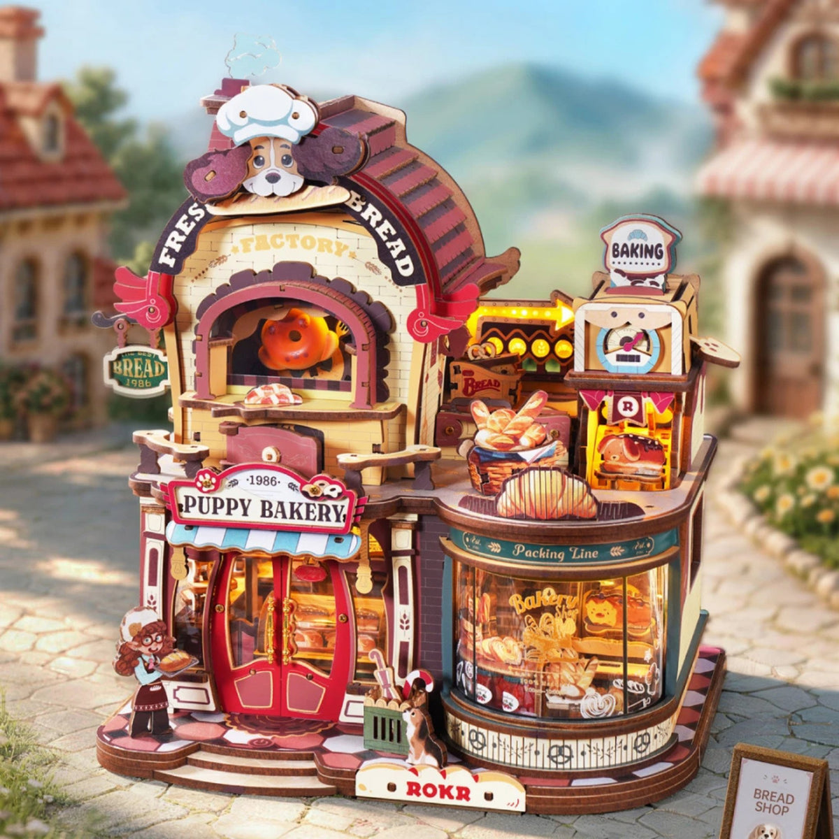 Dream Bread Factory 3D -Maquette en bois : la Puppy Bakery terminée, située dans une rue de village ensoleillée, avec du pain en vitrine