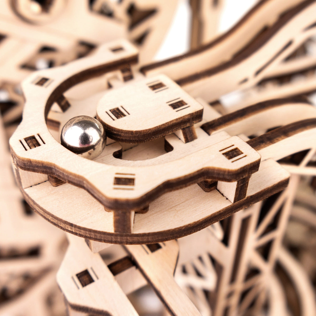 Cyclone Marble Run wooden marble run; a steel marble rolls through the laser-cut curve; close-up