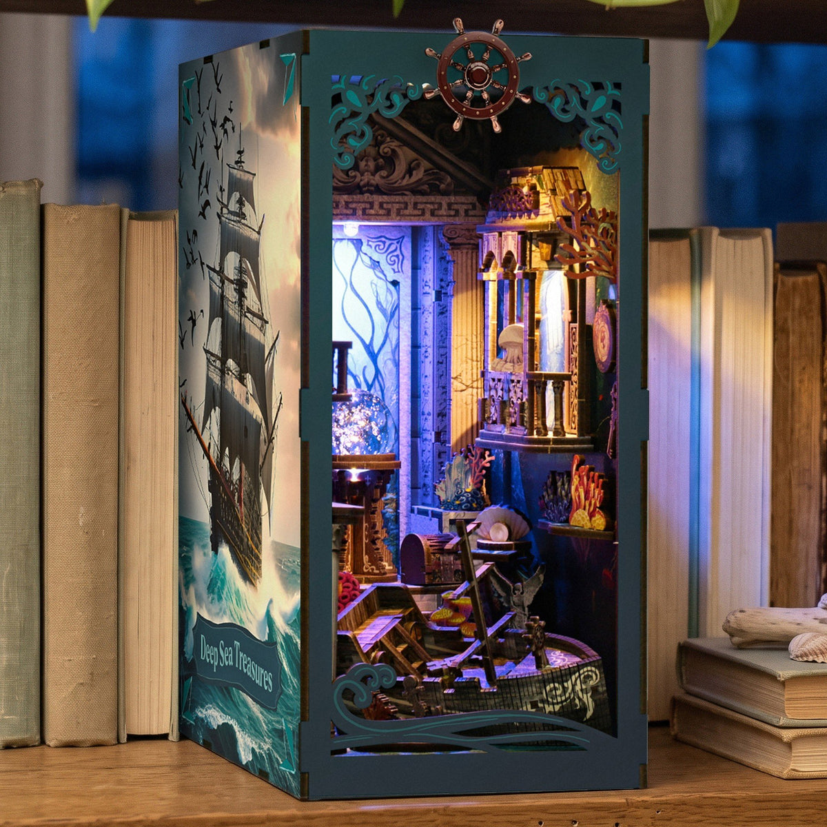 Deep Sea Treasures Book Nook, qui brille le soir sur l'étagère en chêne, avec le panneau latéral MaHo représentant un voilier et le titre