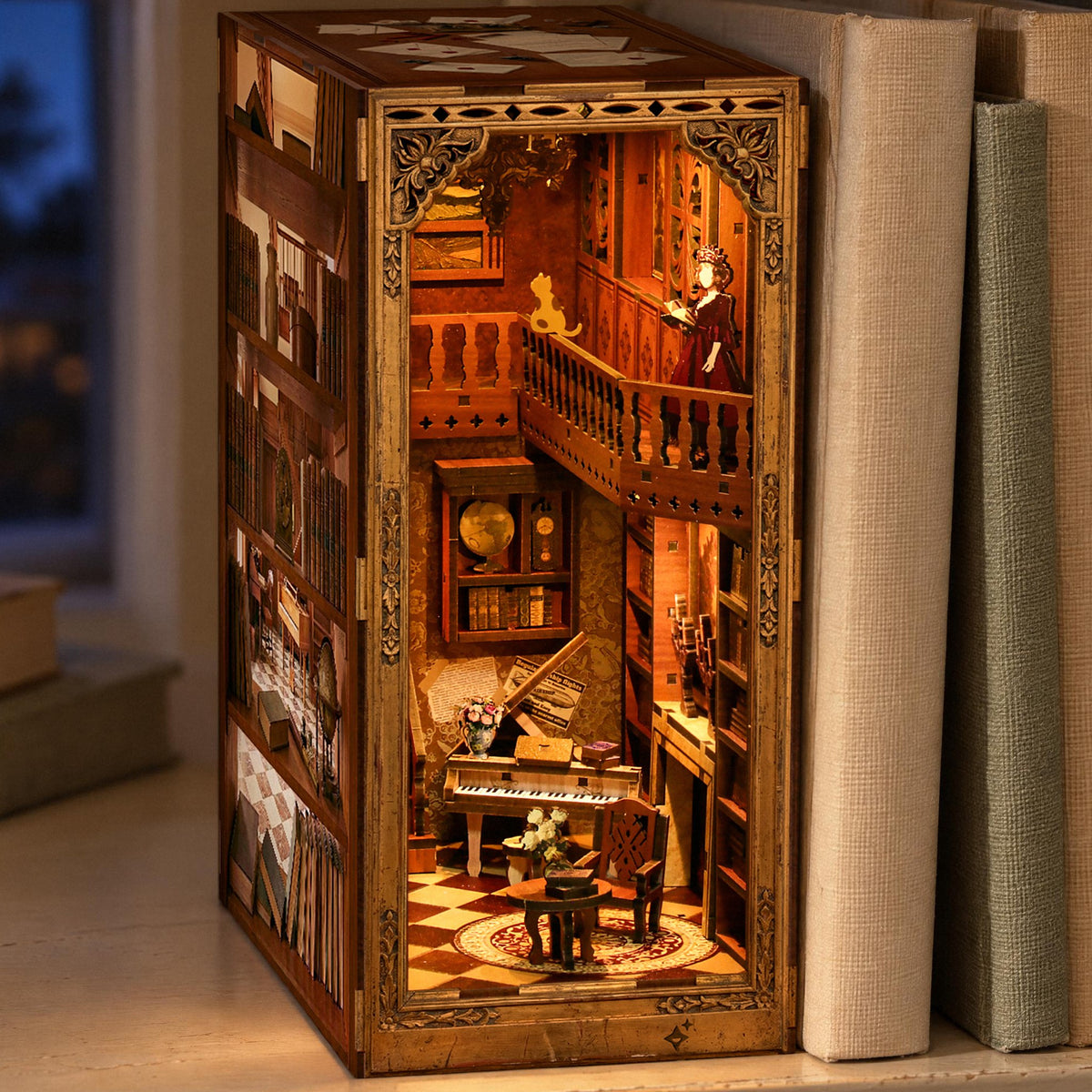 Grimm's Little House Book Nook, a glowing fairy-tale diorama set among the brightly colored books on the shelf in the evening