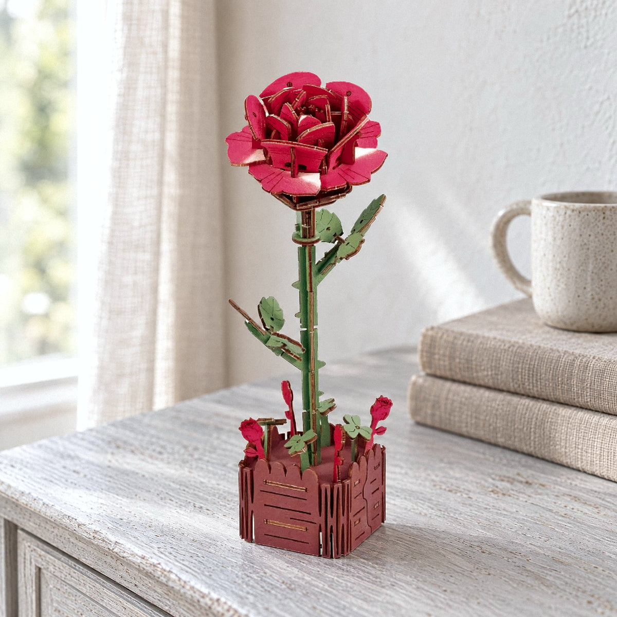 Holzblumen, Rose: rote Holzrose im kleinen Holztopf auf hellem Sideboard bei Tageslicht
