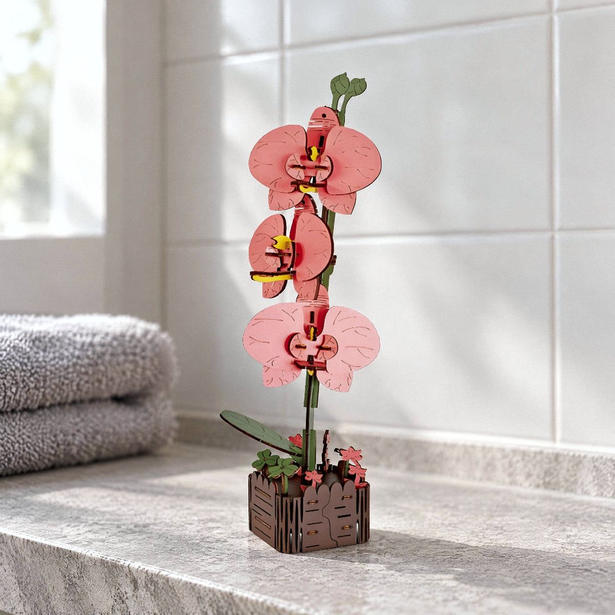 Holzblumen, Orchidee: lachsrosa Holzorchidee mit drei Blüten im Holztopf im Bad