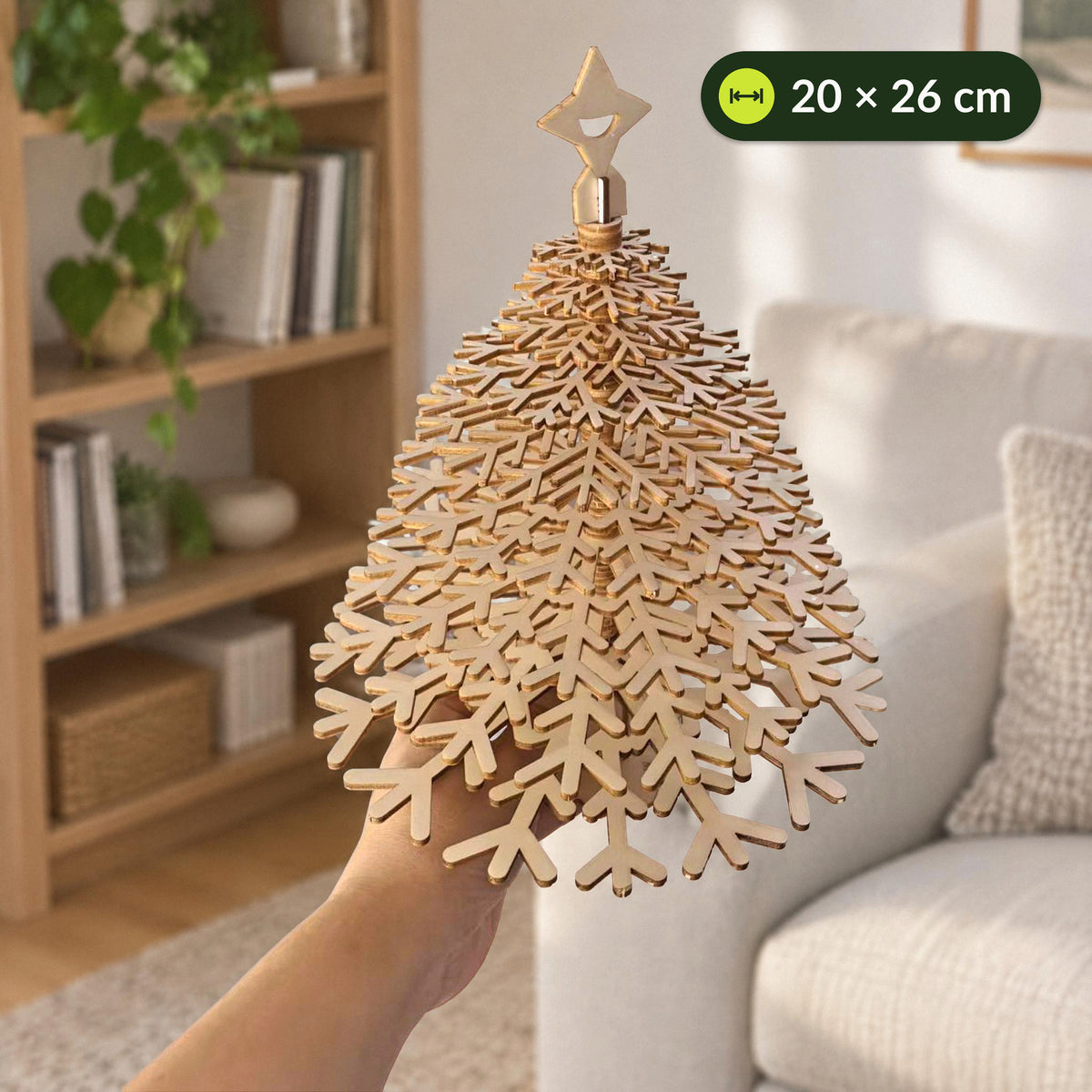 Weihnachtsbaum aus Holz, Größe: eine Hand hält den fertigen Baum von unten, etwa 20 cm breit und 26 cm hoch