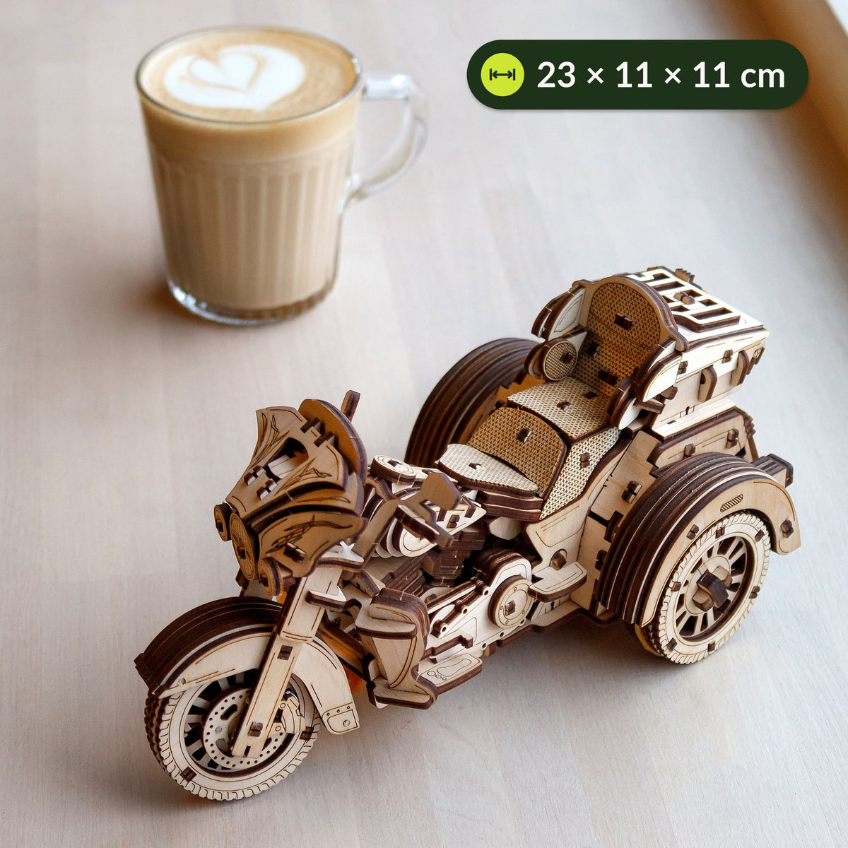 Trike aus Holz neben einer Tasse Cappuccino zum Größenvergleich, 23 × 11 × 11 cm