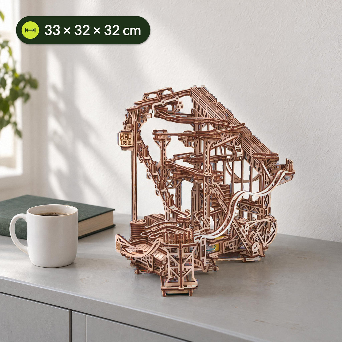 Spiral Murmelbahn Elektrisch aus Holz, neben einer Kaffeetasse auf einem hellgrauen Sideboard, 33 × 32 × 32 cm