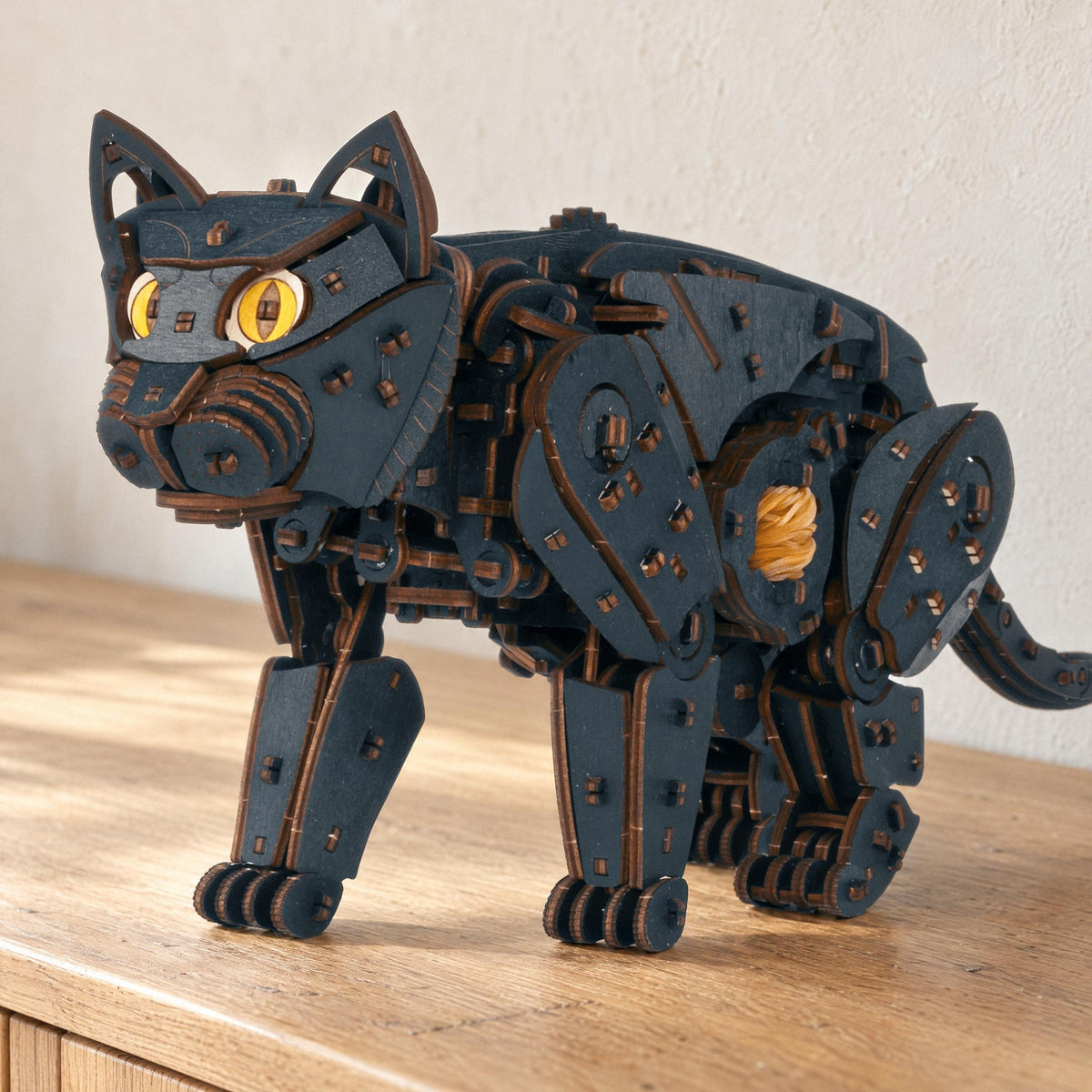 Mechanische katten – naturel of zwart, zwarte houten kat met gele ogen op een lichte eikenhouten ladekast in het ochtendlicht