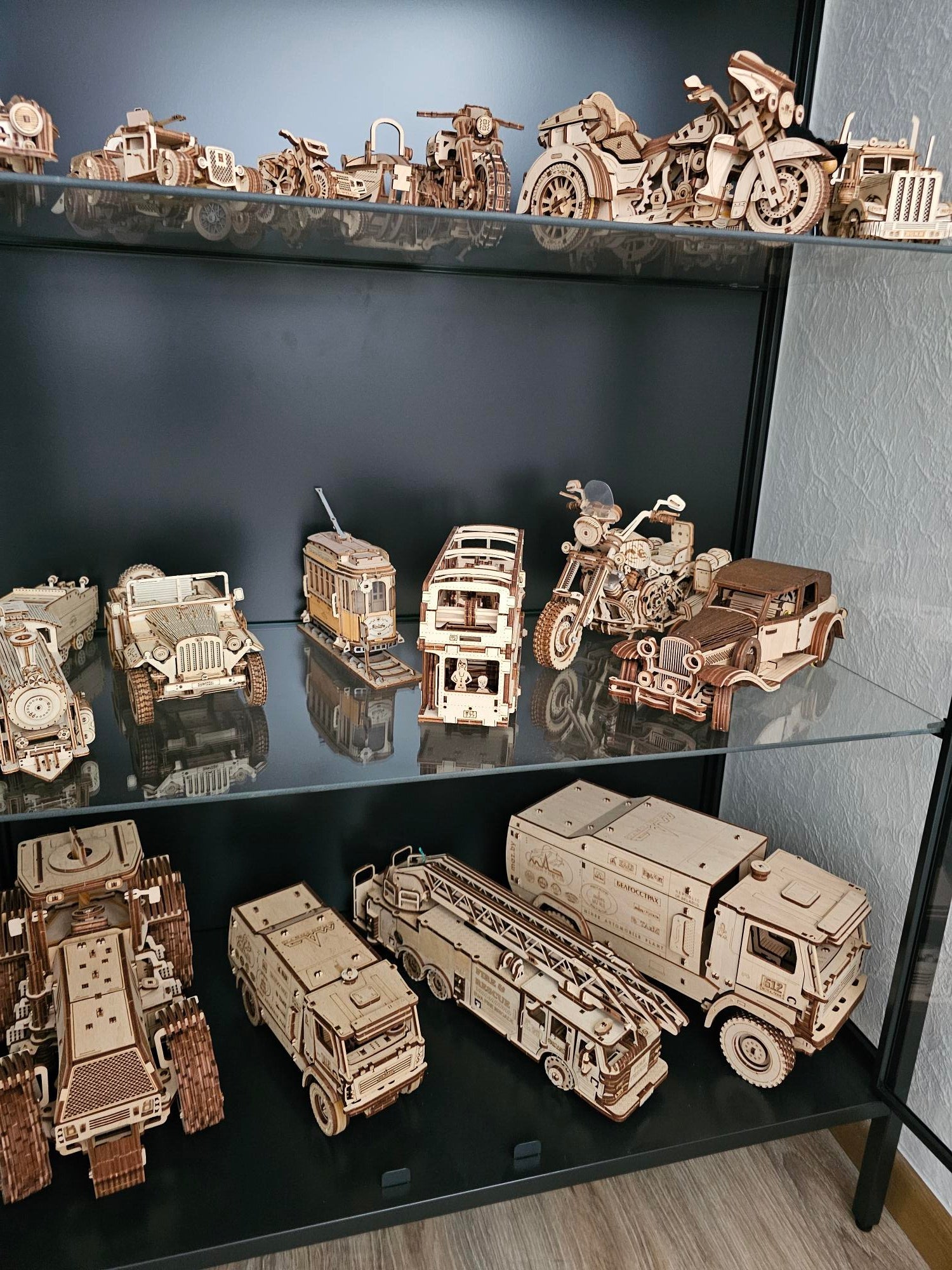 Collection de véhicules en bois miniatures dans une vitrine