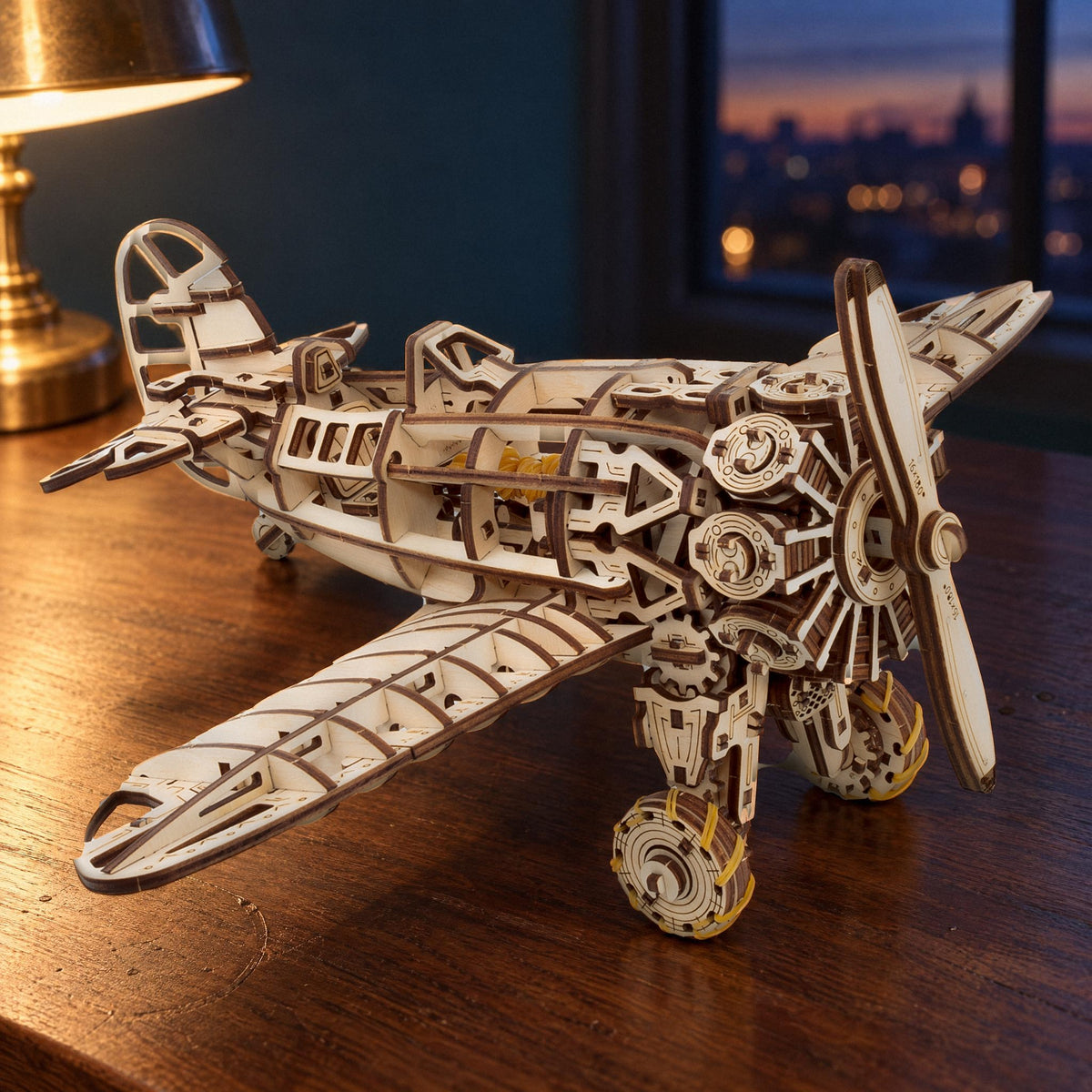 Avion mécanique, maquette en bois finie, dans la lumière du soir, posée sur une table sombre à côté d'une lampe en laiton et d'une fenêtre