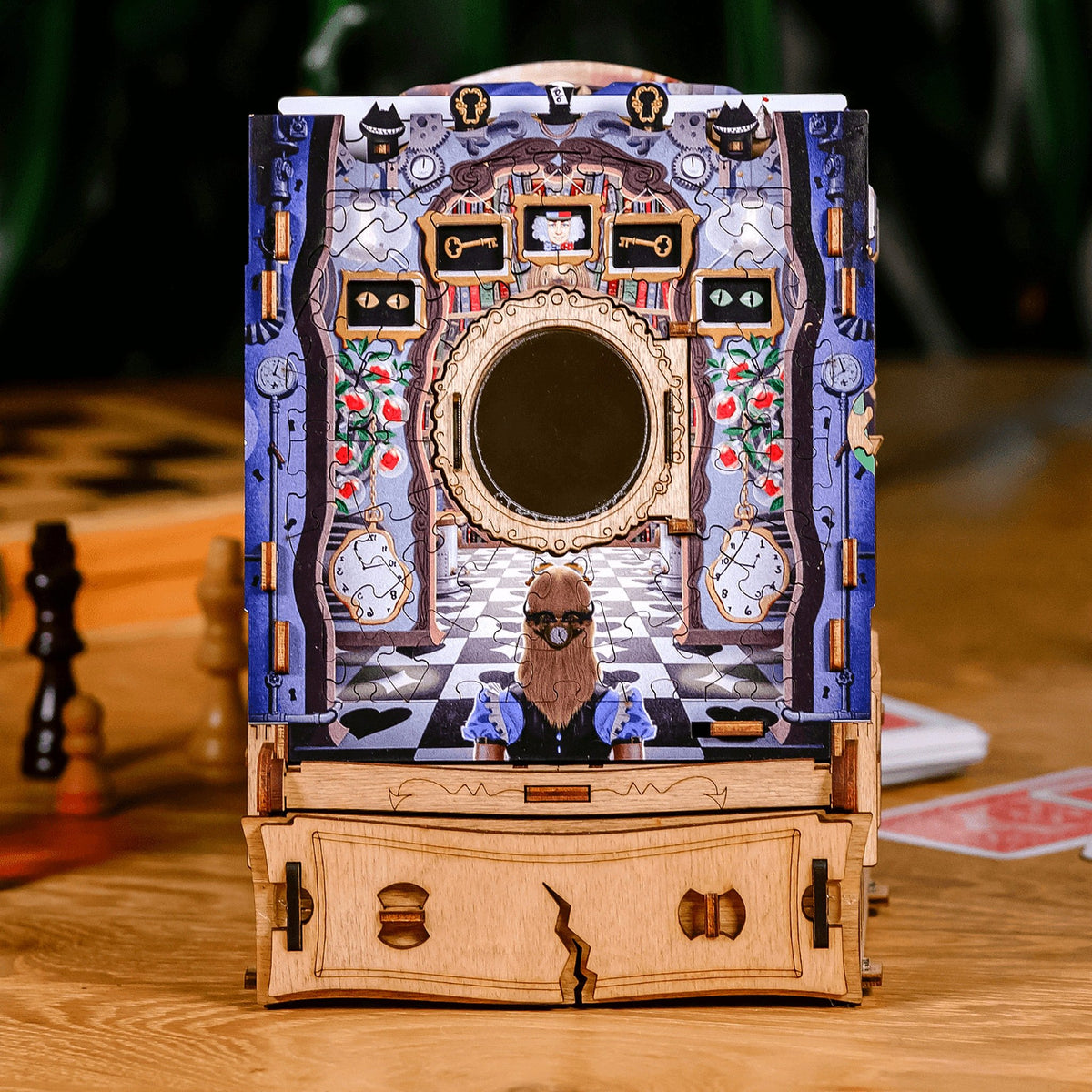 Wonderbox of Alice: een puzzeldoos met een Alice-puzzelafbeelding op een houten tafel, naast schaakstukken en speelkaarten