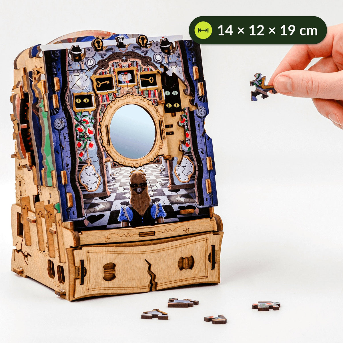 Wonderbox of Alice-puzzeldoos naast een hand met een puzzelstukje om de grootte te vergelijken, ongeveer 14 x 12 x 19 cm