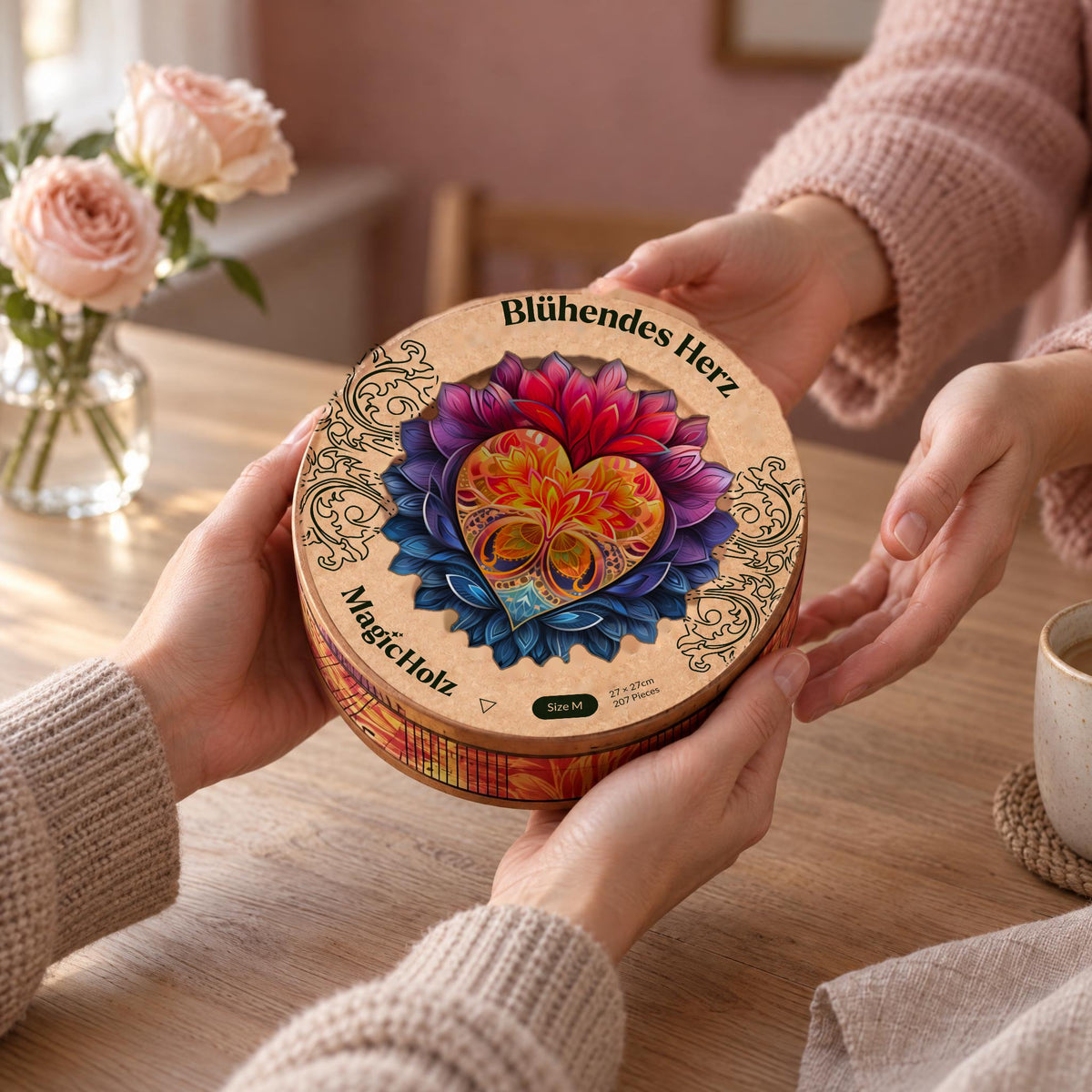 Blühendes Herz Mandala Holzpuzzle, runde Premium-Holzdose mit dem Herz-Motiv wird als Geschenk über den Tisch gereicht