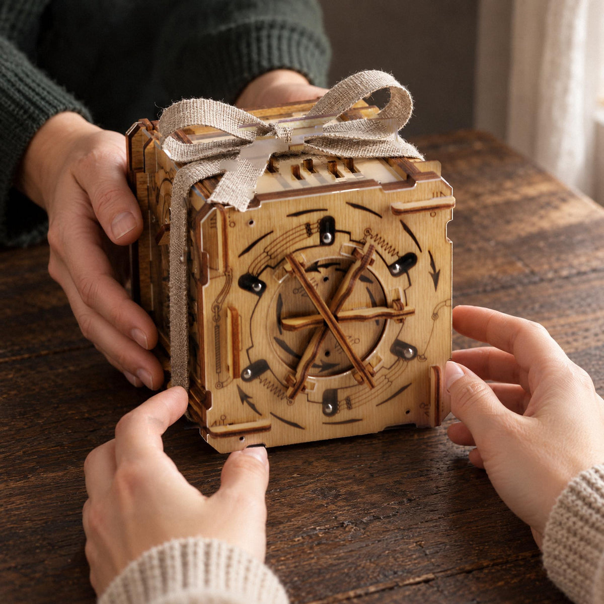 Cluebox Cambridge Labyrinth-puzzelbox, met een linnen lintje eromheen, als cadeautje over de tafel aangereikt