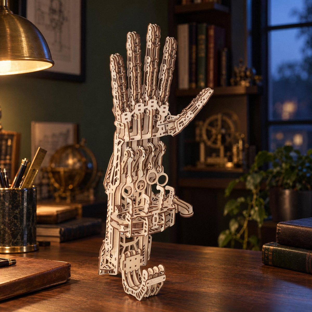 A wooden "cyber hand" sits on a walnut desk in the study in the evening, next to a brass lamp