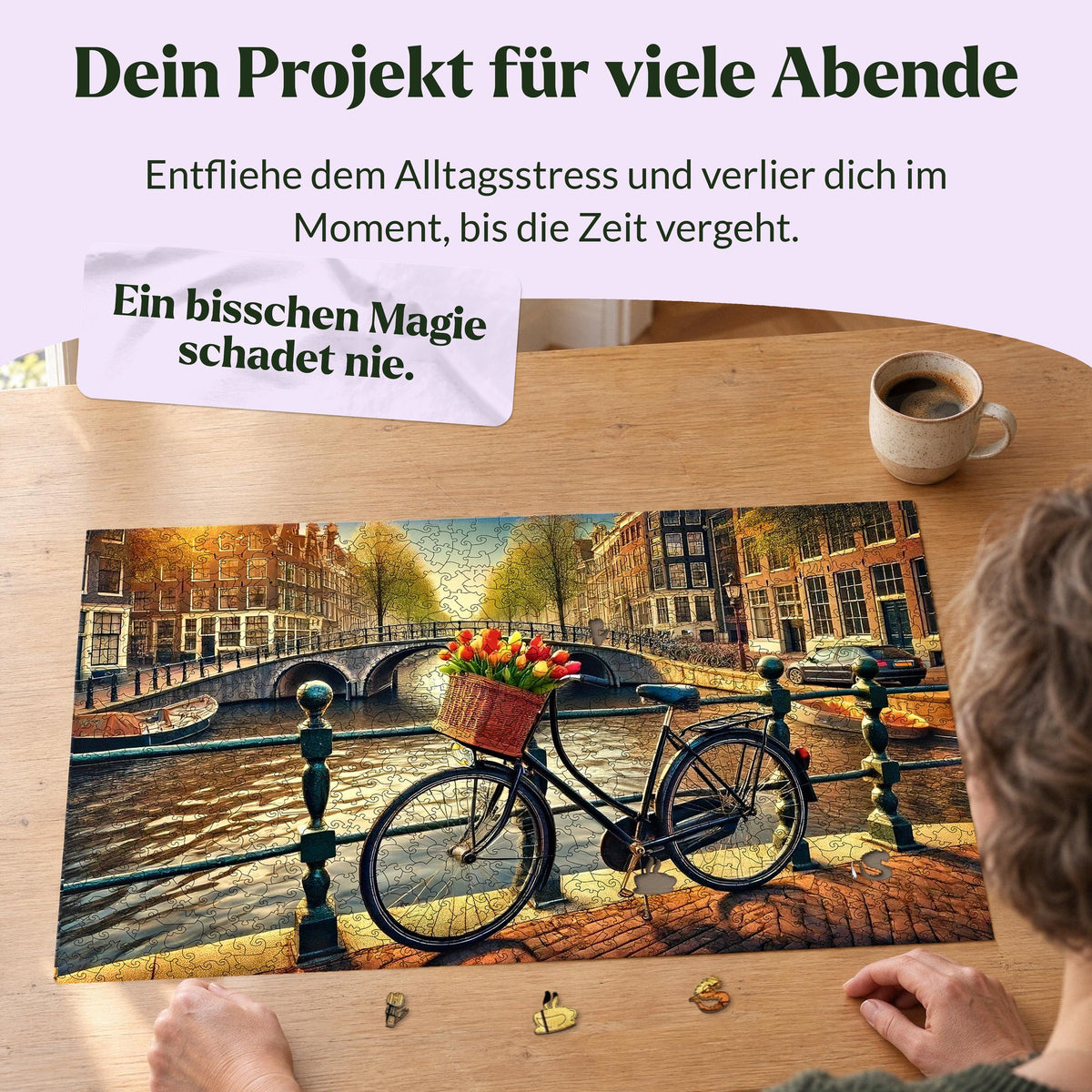 Puzzle en bois « Vélo à Amsterdam » : une femme fait un puzzle sur une table en chêne près de la fenêtre d'un immeuble ancien, avec devant elle une tulipe et une tasse comme pièces du puzzle