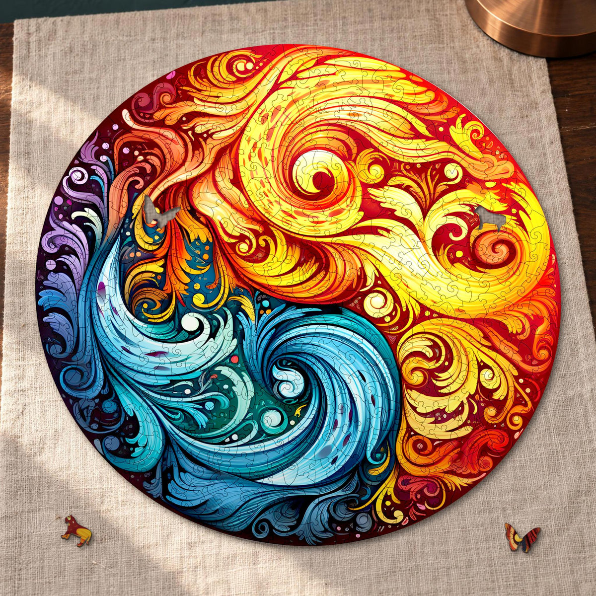 Fire and Water Mandala Wooden Puzzle, round and almost finished on light-colored linen; a lion and a butterfly are still in front of it