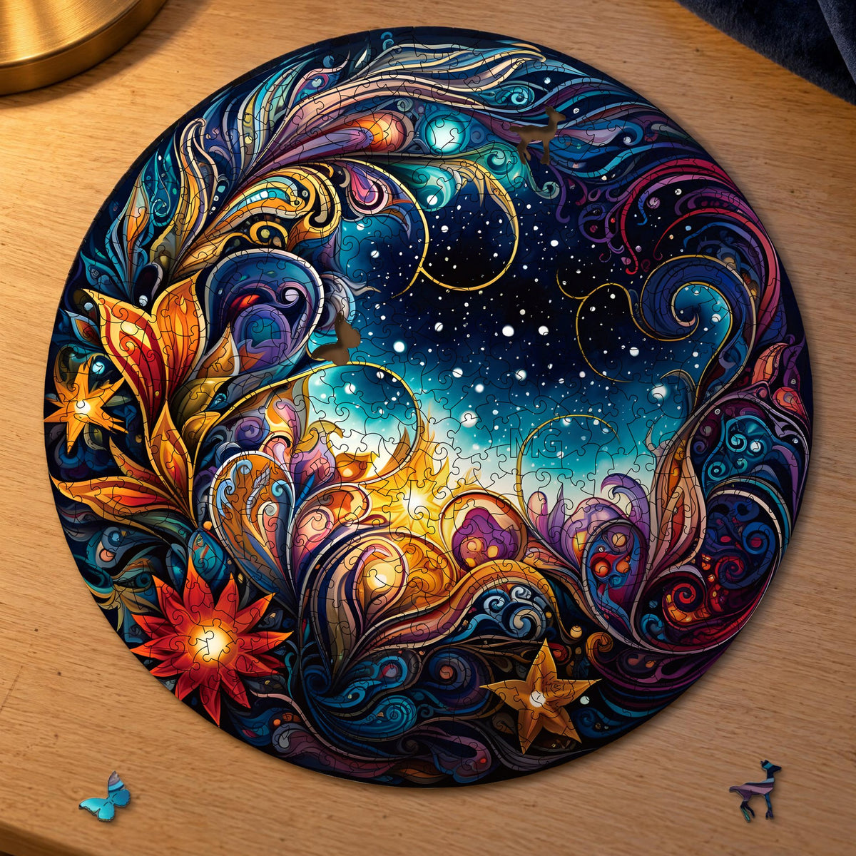 Cosmic Flowers Mandala Wooden Puzzle, round and almost complete on light oak; a butterfly and a deer are in front of it