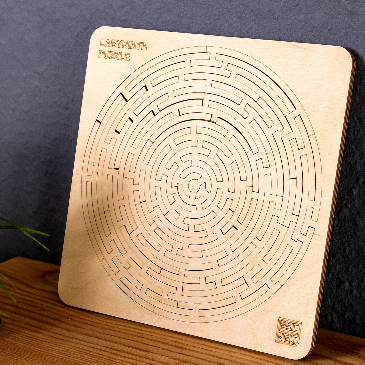 Puzzle « Labyrinthe » de la marque Escape Welt, en bois de bouleau, posé contre un mur sombre sur un buffet en bois