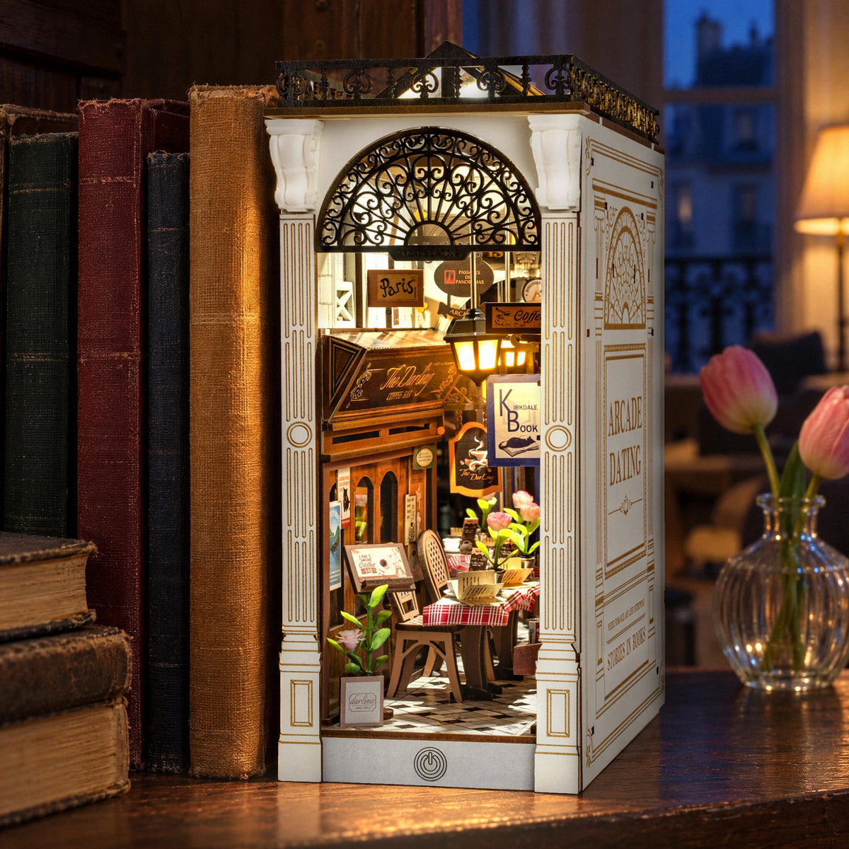 Arcade Dating Book Nook glows on the bookshelf as a bookend in the evening, casting a warm light on the books next to it