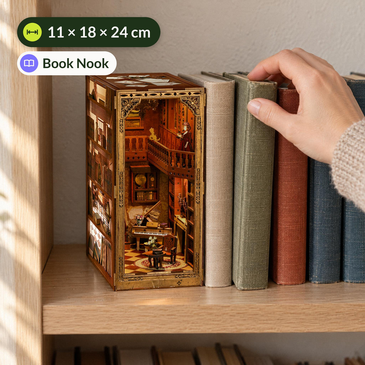 Grimm's Little House Book Nook; on the bookshelf, a hand pulls out a book of the same height; dimensions: 11 × 18 × 24 cm
