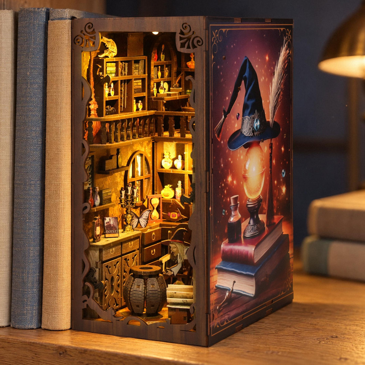 MagicNight Book Nook, a glowing diorama featuring a witch's room set among bright books on an oak shelf against a dark blue wall in the evening