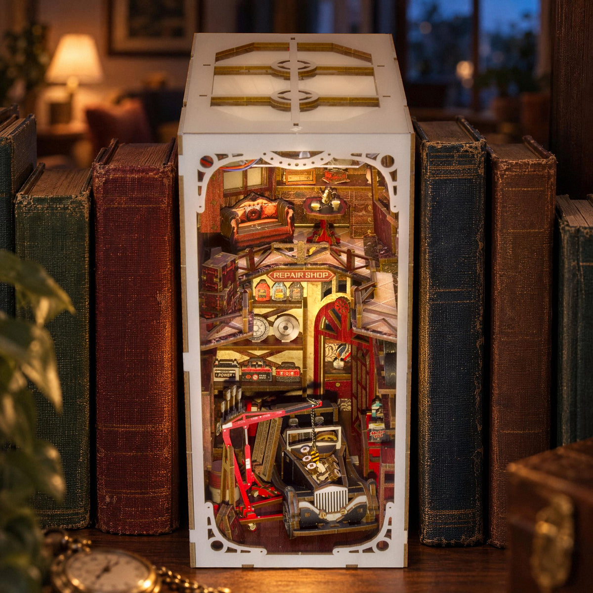 Vintage Car Mechanic Book Nook, viewed from the front on the bookshelf in the evening: A view into the workshop with a classic car, a crane, and a lounge
