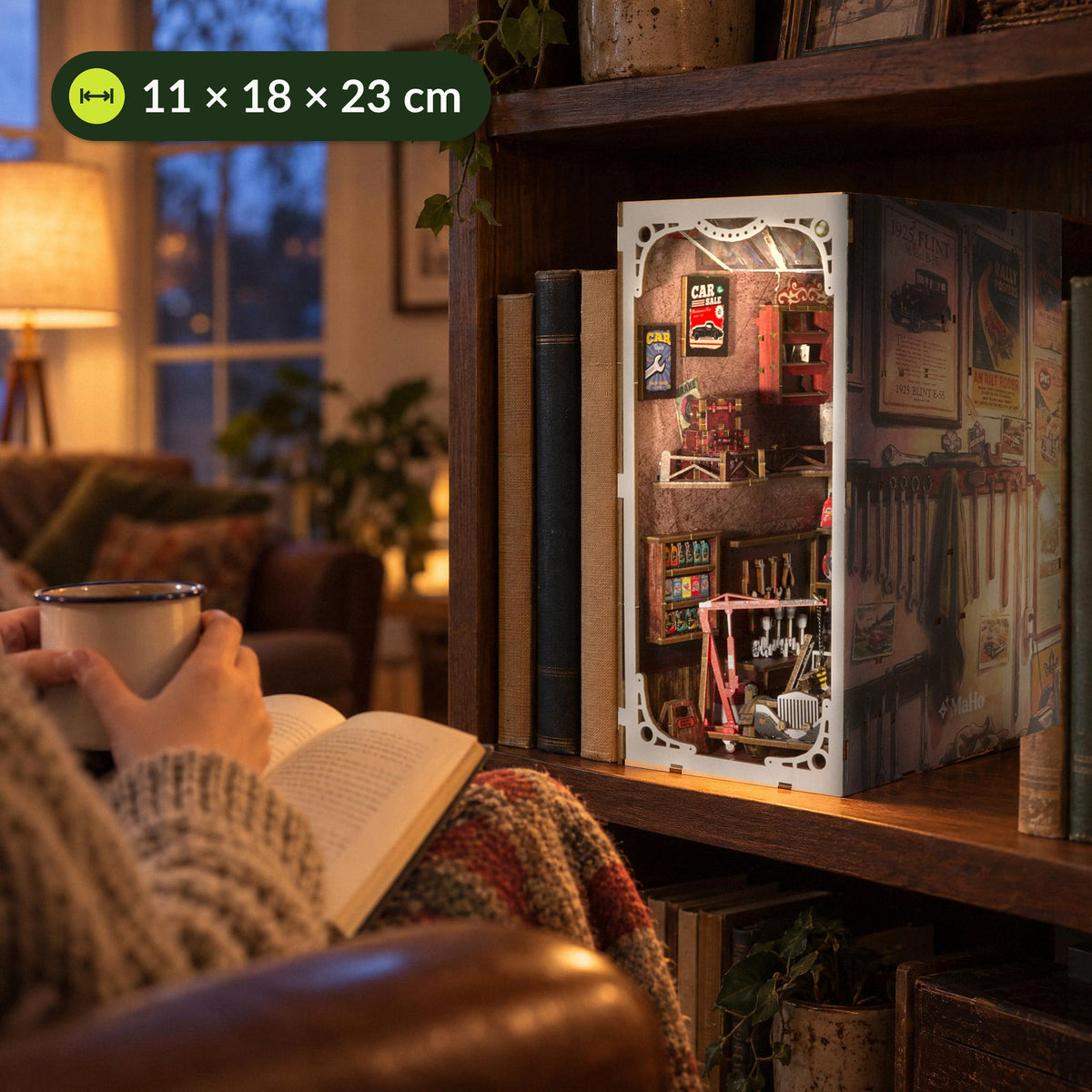 "Vintage Car Mechanic Book Nook," on the living room shelf, with a cup of tea and a book in the armchair in front of it, measuring 11 × 18 × 23 cm
