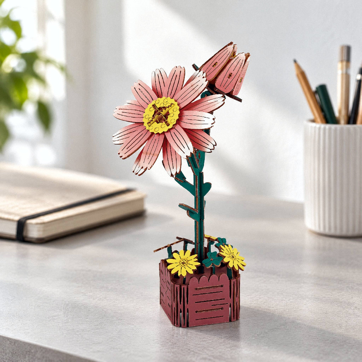 Holzblumen, Gänseblümchen: rosa Holzblüte mit Knospe im Holztopf auf dem Schreibtisch