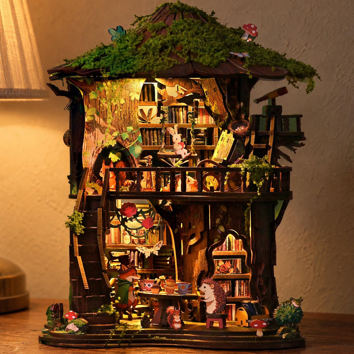Magisch boomhuisje, ’s avonds verlicht op een eikenhouten dressoir, ernaast een tafellamp met een linnen lampenkap