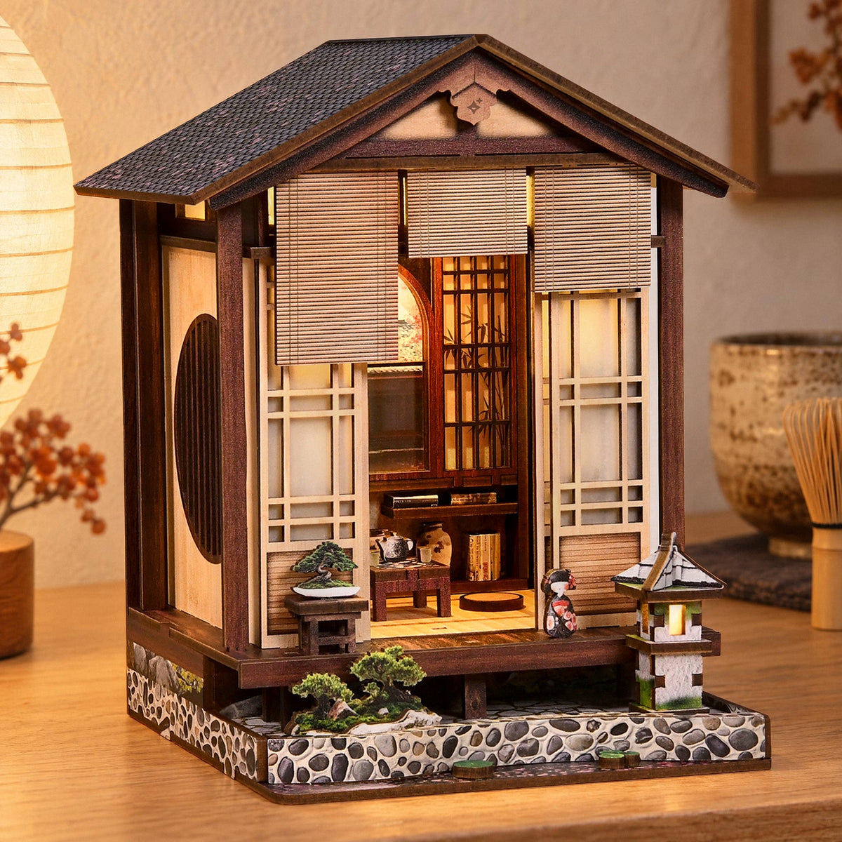 Japanese Teahouse Miniaturhaus, leuchtet abends auf dem Sideboard, warmes Licht hinter Rollos und Papierwänden