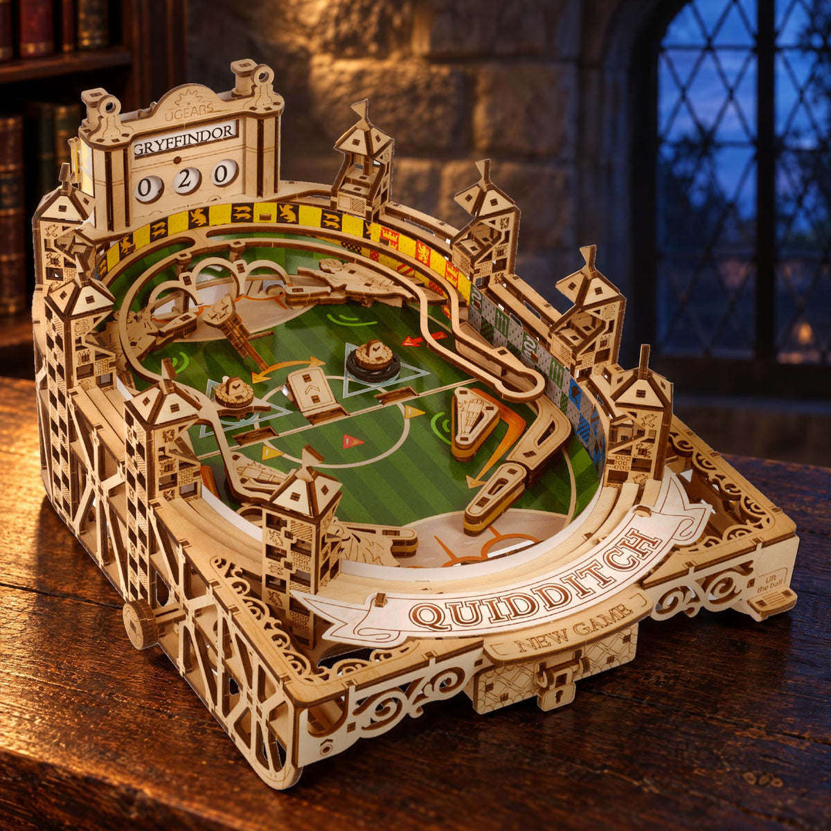 A wooden Quidditch pinball set on an oak table in the Stone Room with a Gothic stained-glass window at twilight