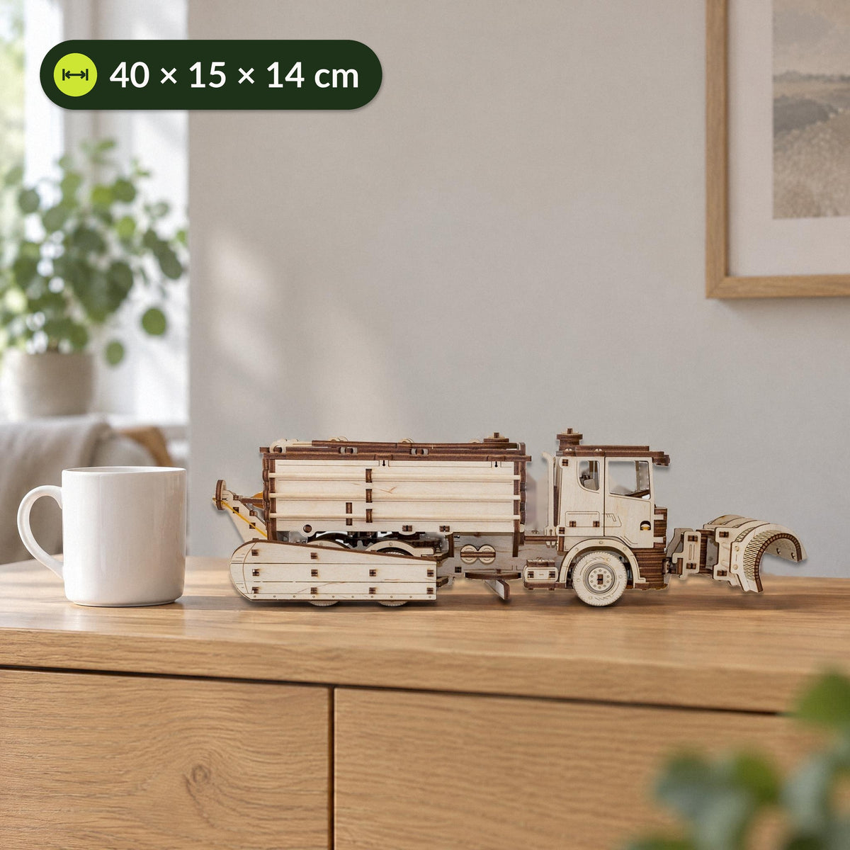 Schneeräumer Holzmodell neben einer Kaffeetasse auf dem Sideboard, 40 × 15 × 14 cm groß, mechanischer Bausatz