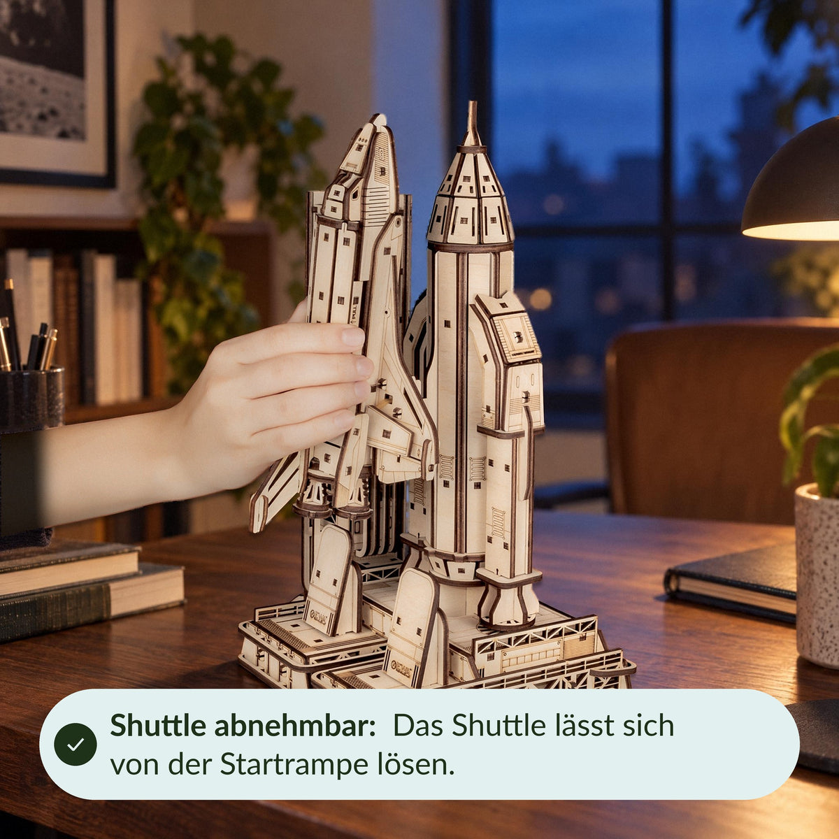 Wooden Space Shuttle model; one hand releases the shuttle from the launch pad; the shuttle is removable