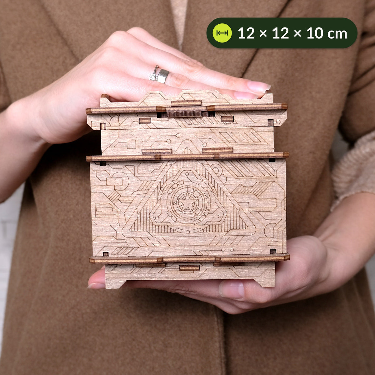 Boîte à énigmes Orbital Box, tenue à deux mains, d'environ 12 cm de large et 10 cm de haut, avec un motif gravé