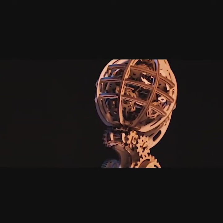 Video: The wooden kinetic globe rotates its inner and outer spheres in opposite directions, powered by a rubber band motor