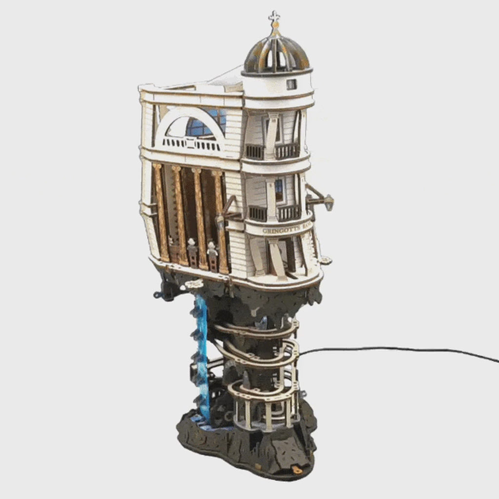 Le circuit à billes de la banque Gringotts en action : les billes dévalent les pistes en spirale, et l'ascenseur en cascade les ramène tout en haut