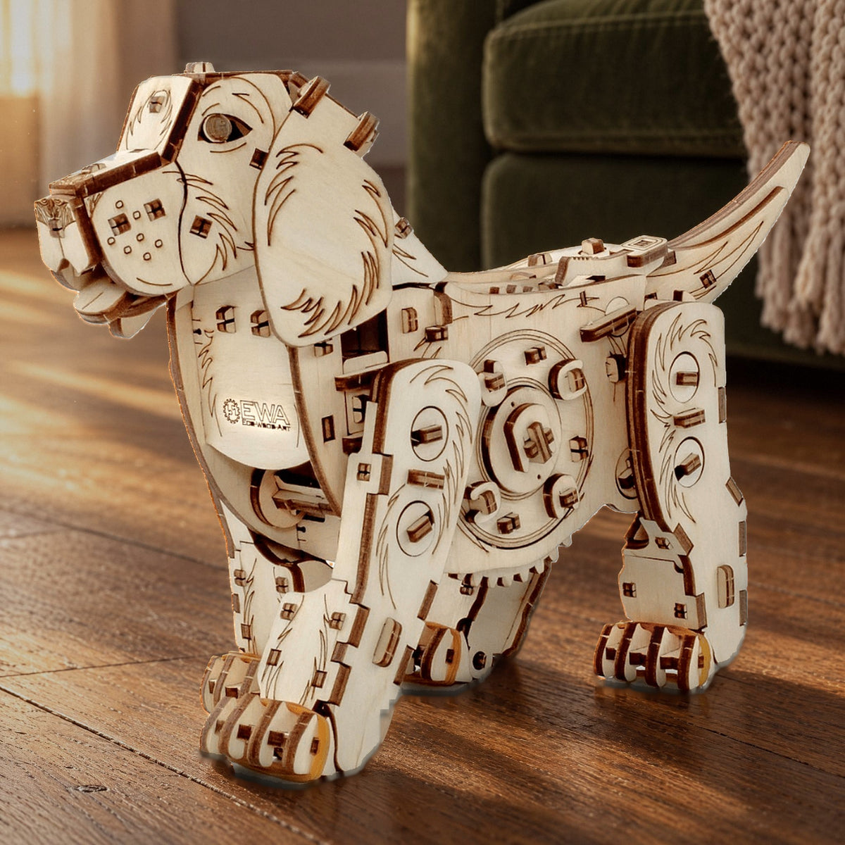 Mechanical dog, a finished wooden puppy on oak floorboards in the warm late-afternoon light in front of a green velvet sofa