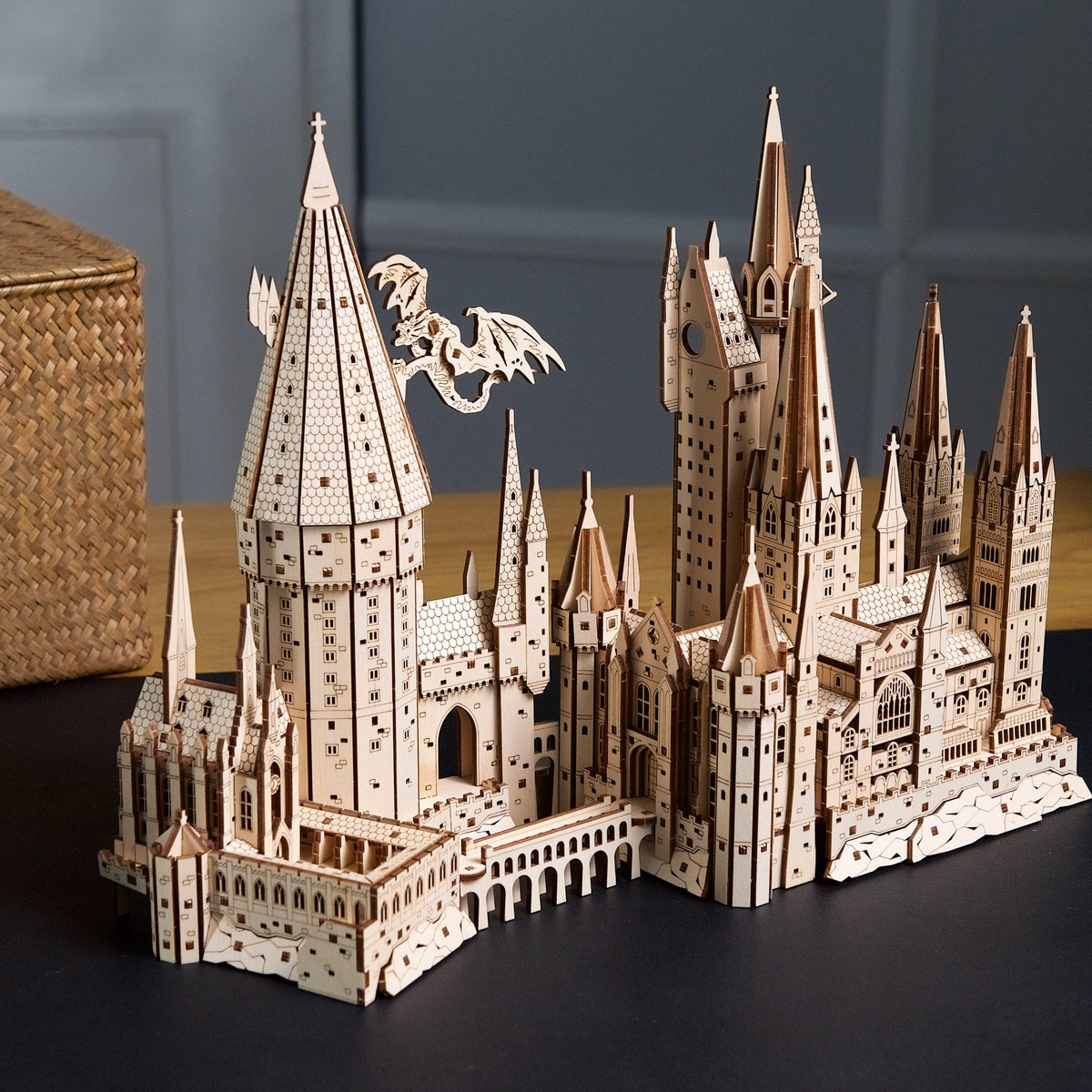 Hogwarts Castle – Harry Potter, a fully assembled wooden model by Ugears on a dark desk in front of a gray wall