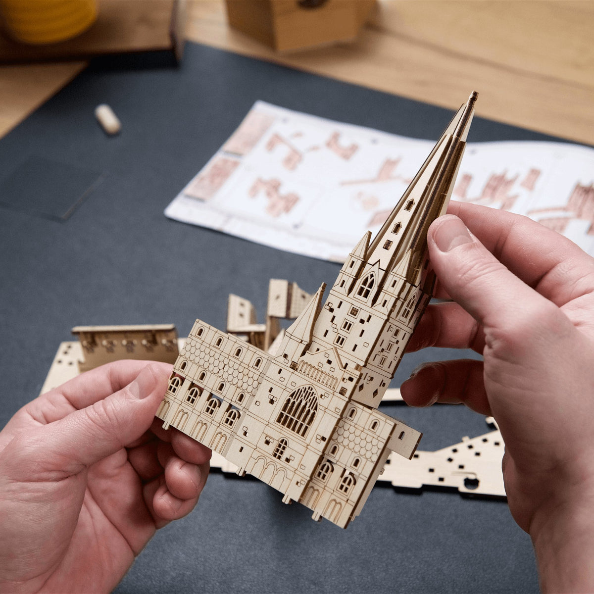 Le château de Poudlard – Harry Potter en train de construire : deux mains assemblent une tour à partir de pièces en bois