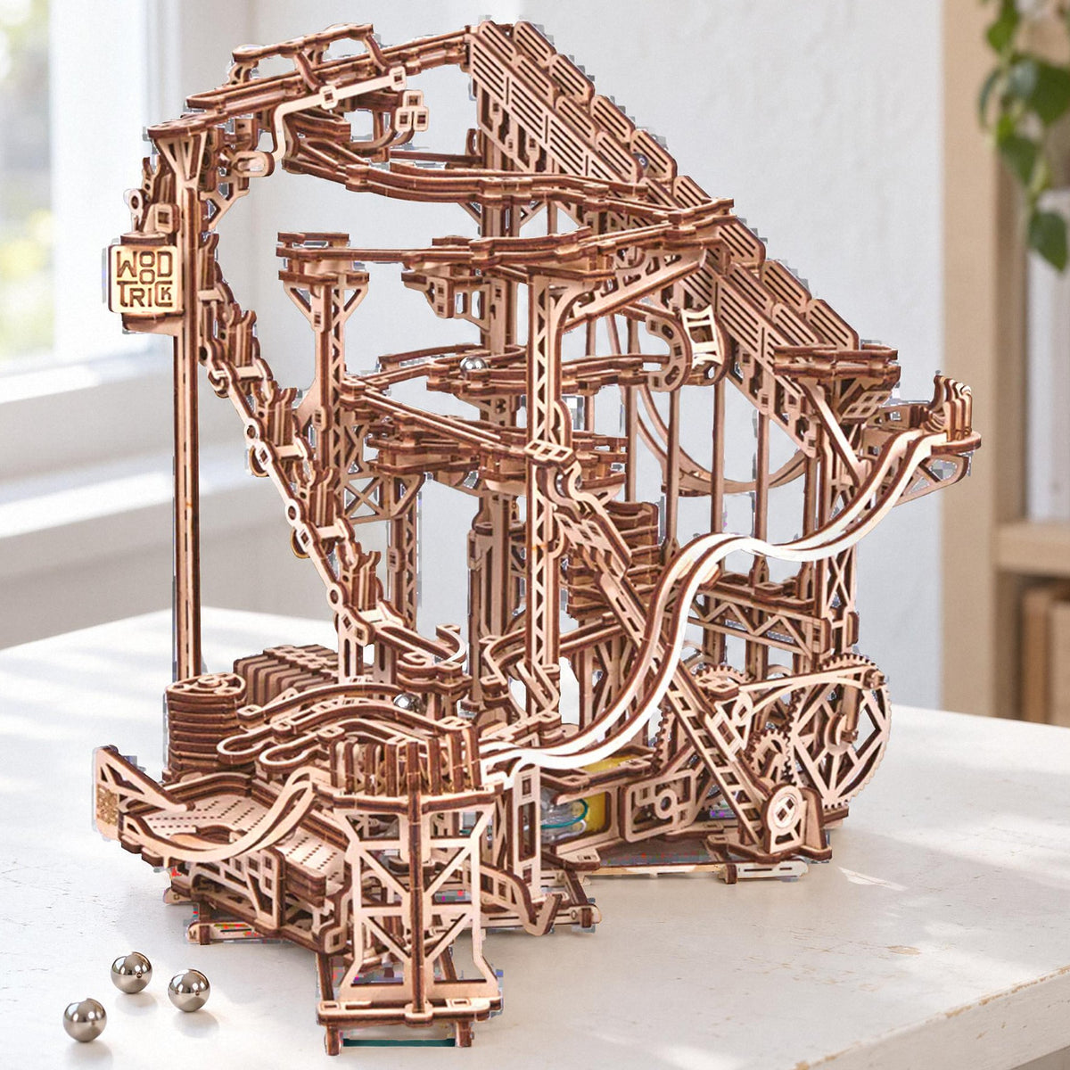 Electric wooden spiral marble run, fully assembled on a white desk in bright daylight