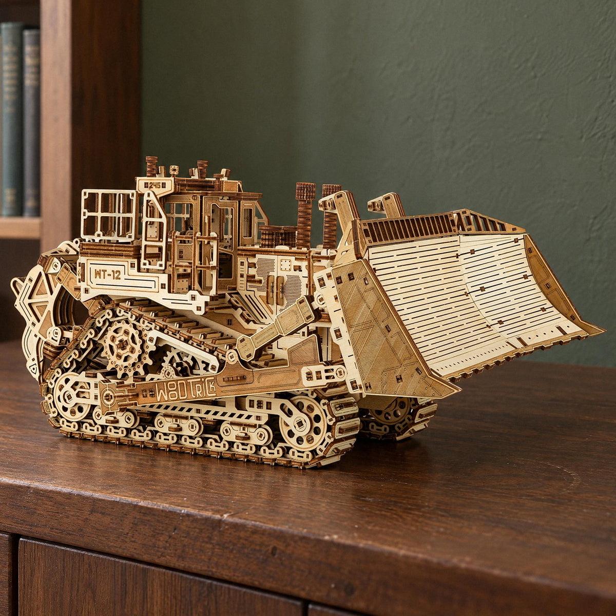 Terrain Titan Bulldozer houten bouwpakket, afgewerkt model op een notenhouten dressoir voor een groene muur in daglicht