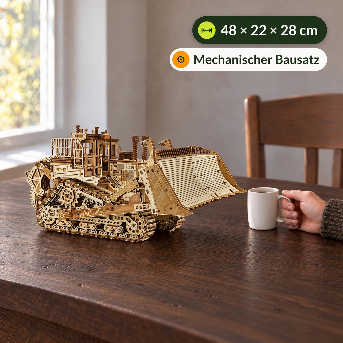 Terrain Titan Bulldozer Maquette en bois, à côté d'une tasse à café sur la table à manger, la main posée sur l'anse, 48 × 22 × 28 cm