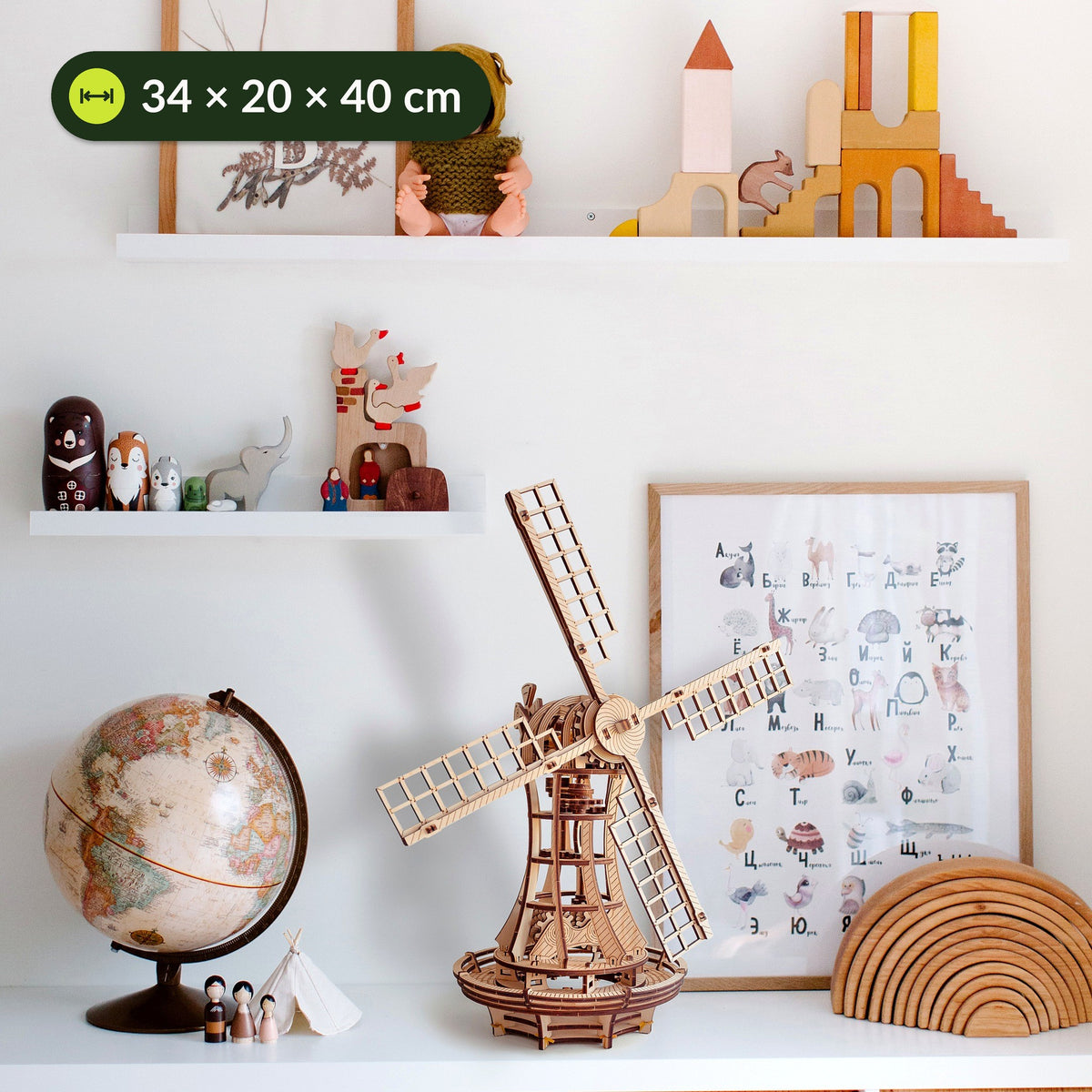 Moulin à vent mécanique en bois dans une chambre d'enfant, posé sur une table à côté d'un globe terrestre et de jouets, dimensions : 34 × 20 × 40 cm